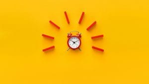 alarm clock with red dominoes on yellow background