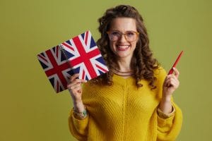 smiling woman in sweater and glasses isolated on green